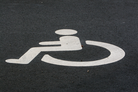 Foto af hvidt handicapsymbol på asfaltbelægning